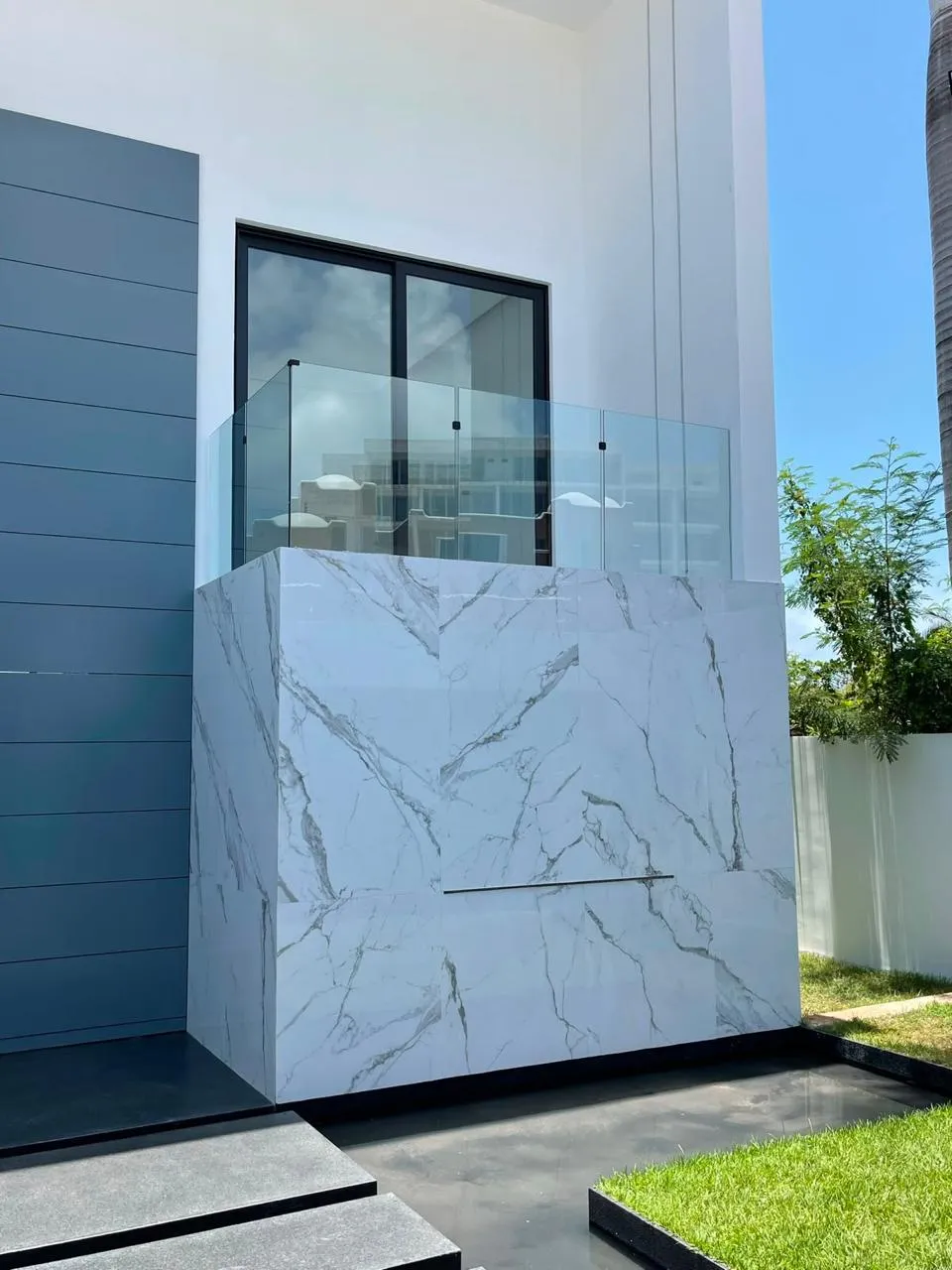 Barandal de cristal templado en balcón exterior con antepecho de mármol