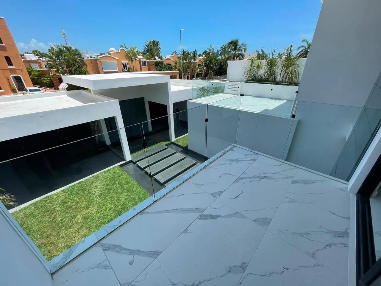 Terraza en azotea con barandal de cristal templado y vista urbana