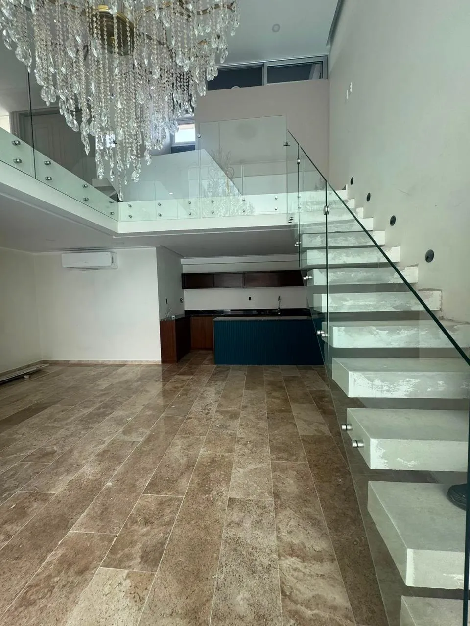 Escalera flotante con barandal de cristal templado y candil de cristal