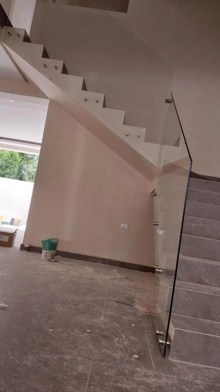 Barandal de cristal templado en escalera con botones de acero