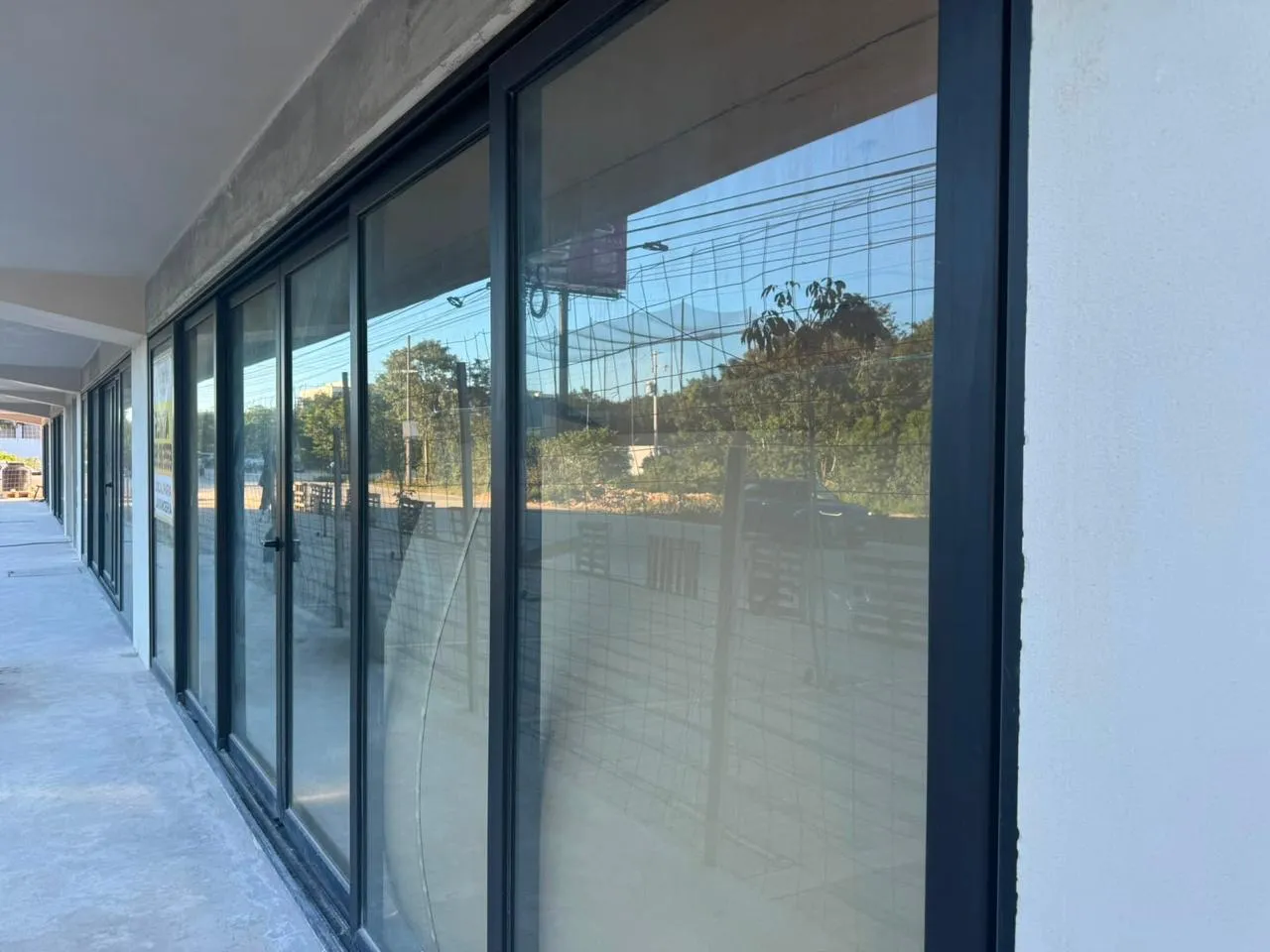 Corredor comercial con canceles corredizos de aluminio negro y cristal