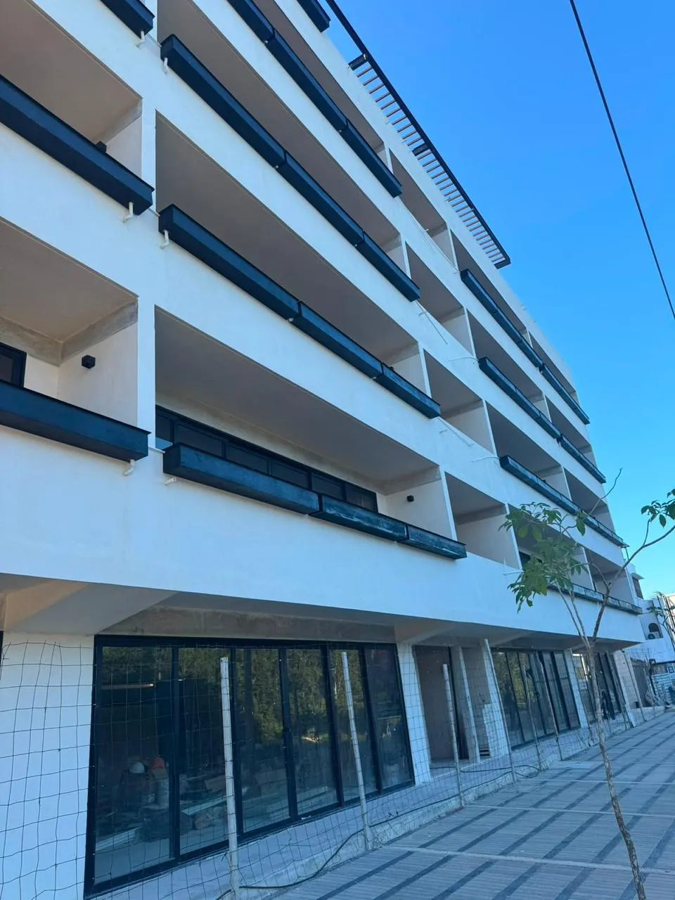 Fachada de edificio con ventanería de aluminio negro en Mérida