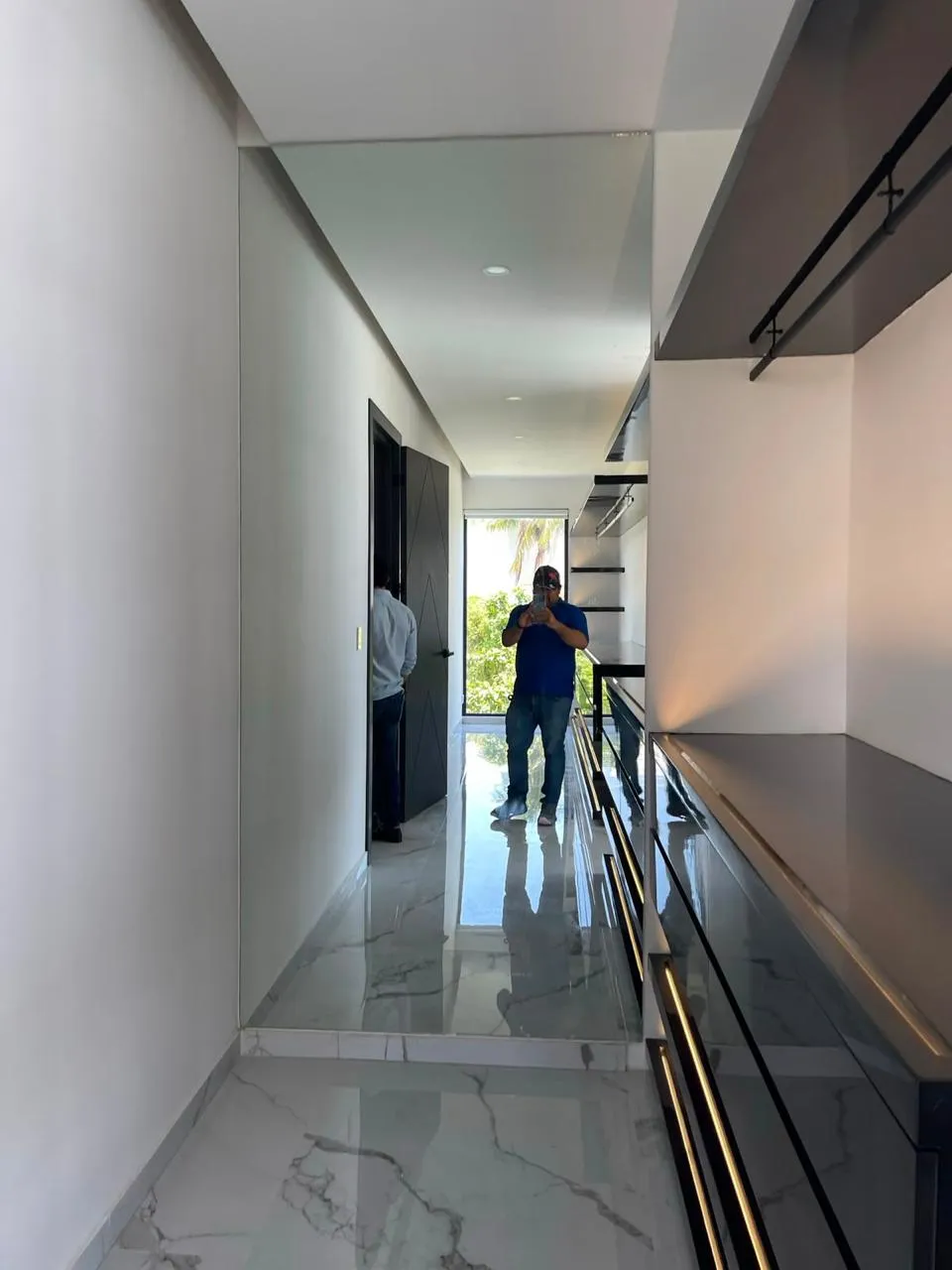 Barandal metálico negro en pasillo interior con piso de mármol