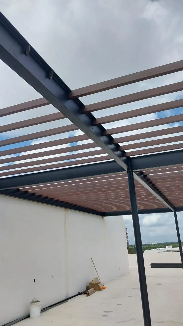 Pérgola de estructura de acero con largueros café en azotea