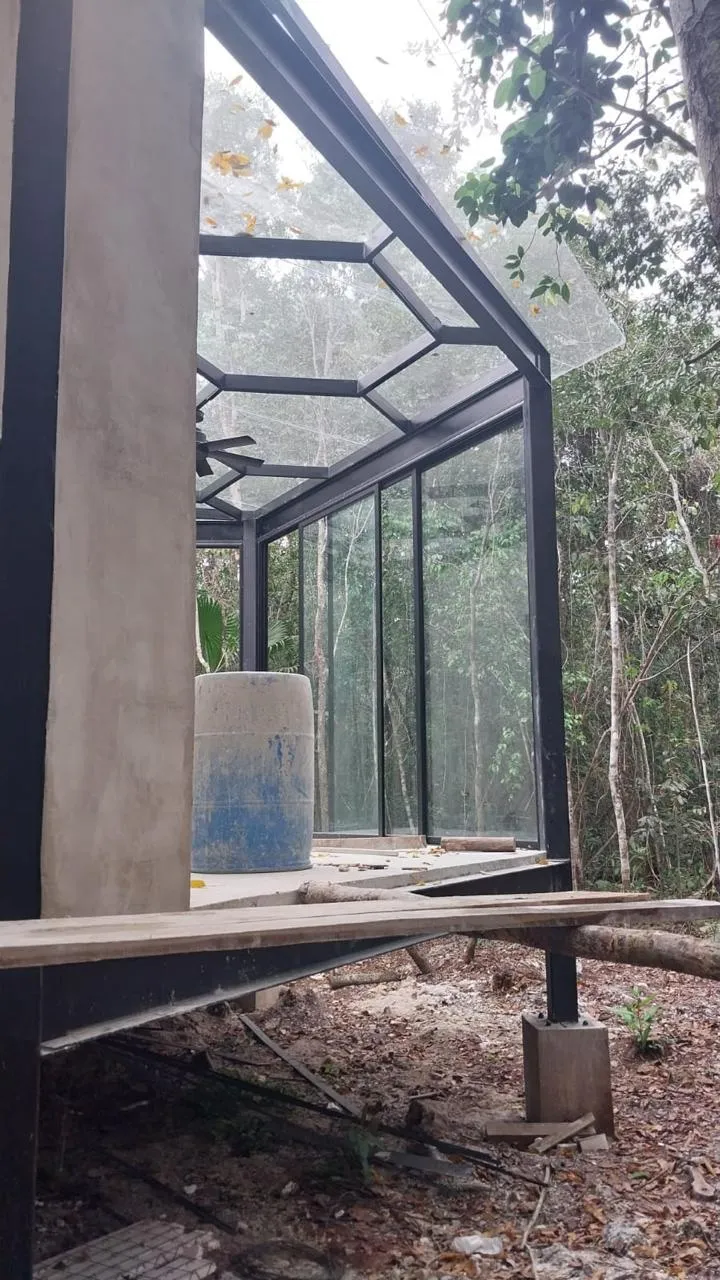 Estructura de acero negro con domo de cristal en selva