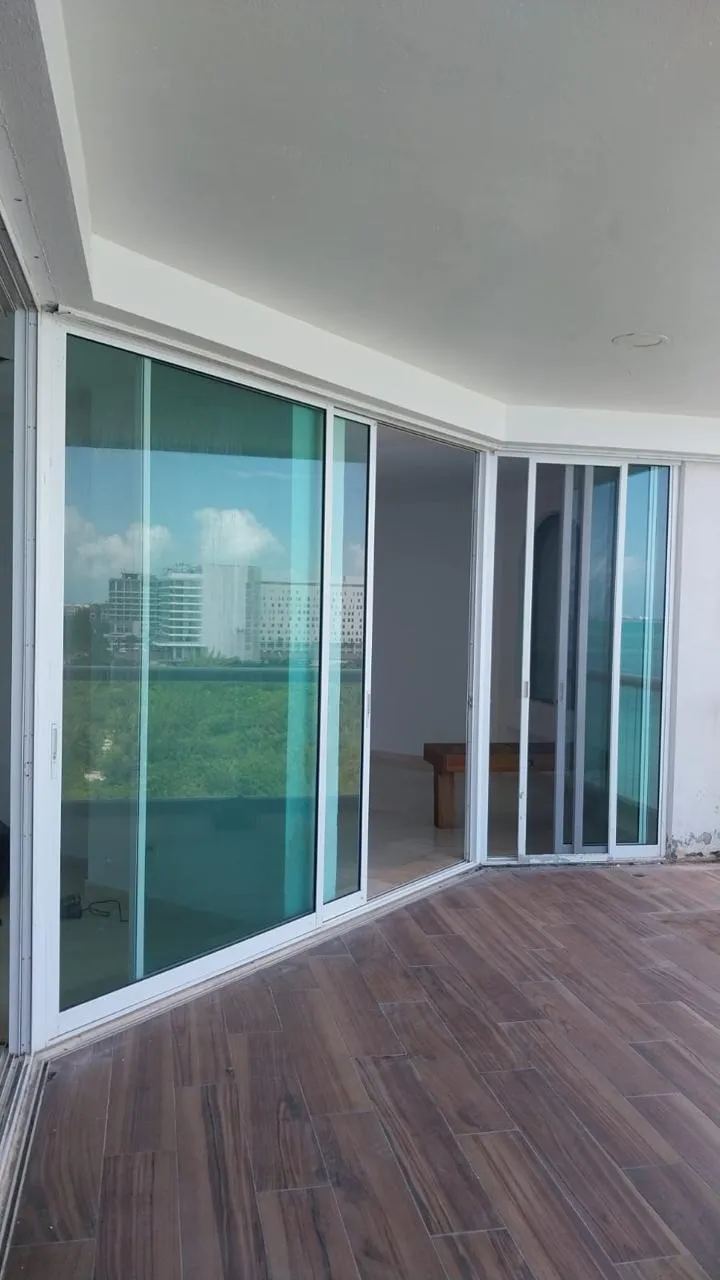 Puertas corredizas de aluminio blanco en terraza con vista al mar