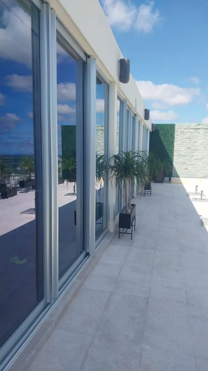 Terraza en azotea con cancelería corrediza de aluminio y macetas