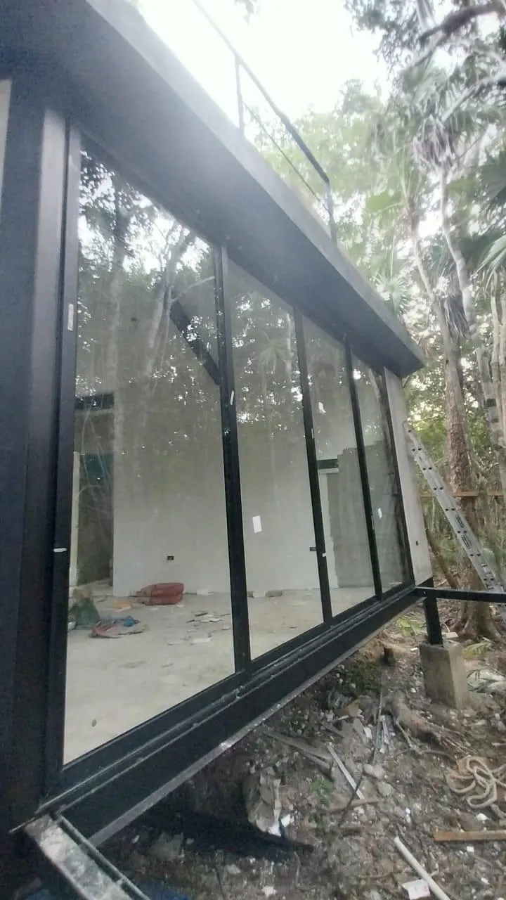 Ventanal de aluminio negro con cristal en casa dentro de selva