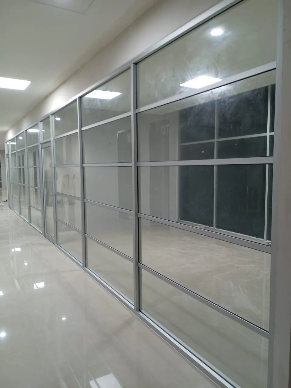 División de oficina en aluminio y cristal a lo largo de pasillo