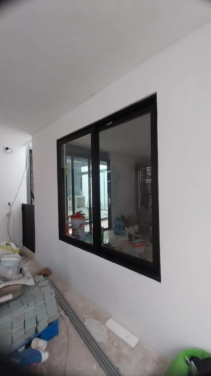 Ventana corrediza de aluminio negro en interior en construcción