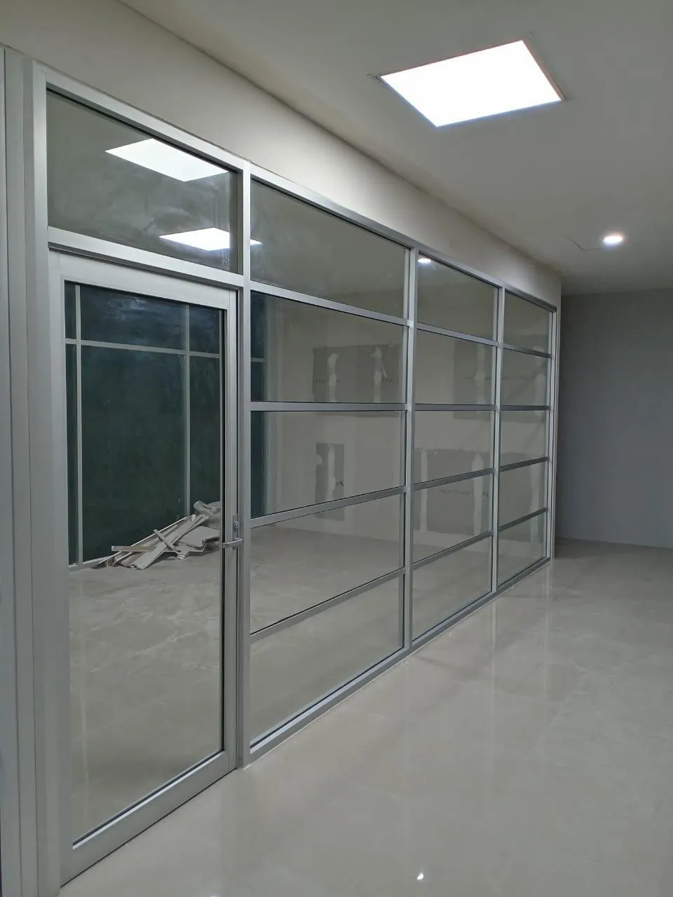 División de oficina en aluminio y cristal con puerta abatible